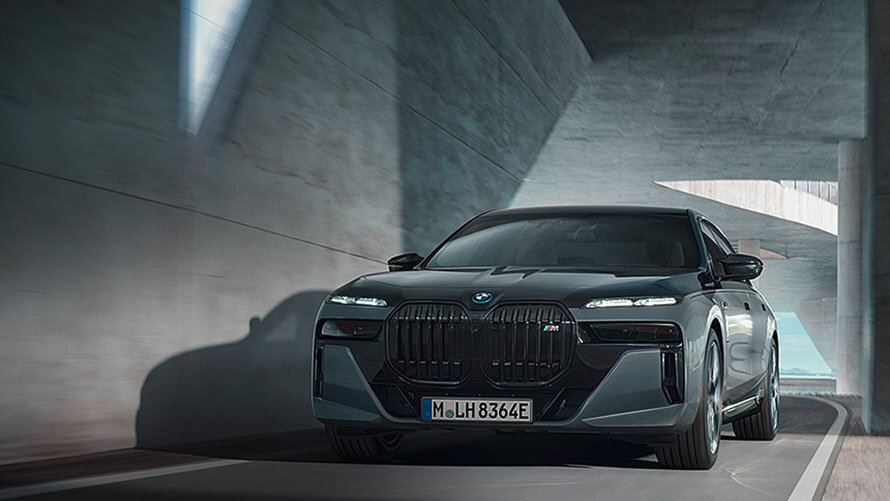 Ein schwarzer BMW M7 fährt durch einen modernen, lichtdurchfluteten Tunnel.