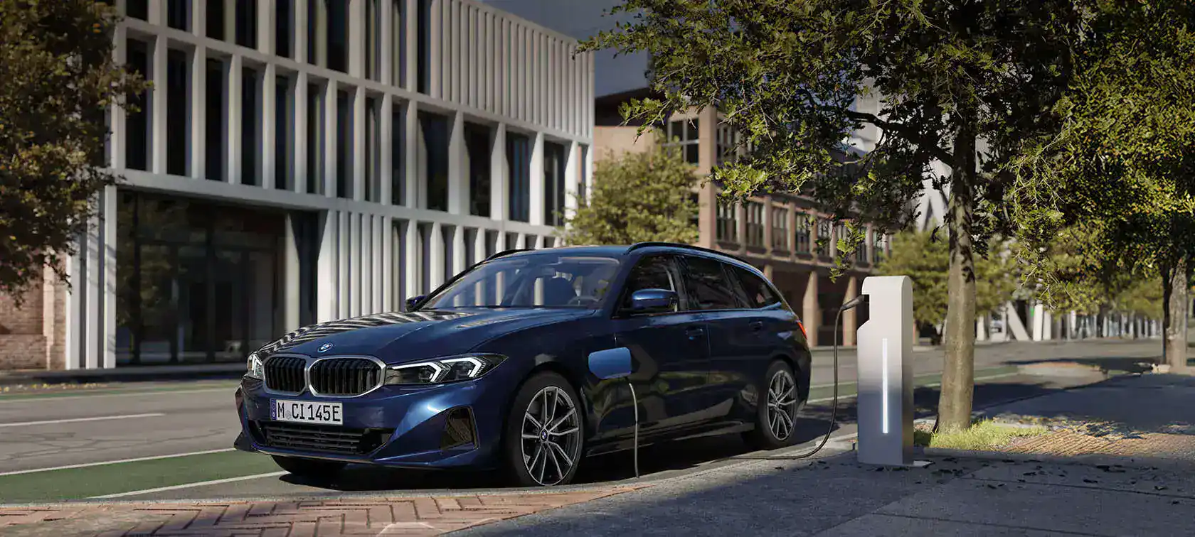 BMW 3er Touring Plug-in-Hybrid in Blau an öffentlicher Ladesäule vor moderner Architektur