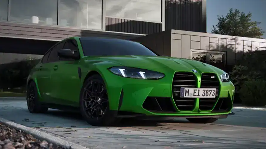 Grünes BMW M-Modell vor modernem Gebäude; sportliches Design; Tageslichtaufnahme.