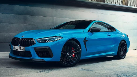 Blaues BMW Coupé mit schwarzen Felgen, in einer modernen, urbanen Umgebung geparkt.