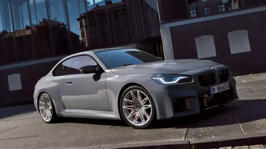 Graues BMW Coupé parkt vor einem modernen Gebäude bei Tageslicht.