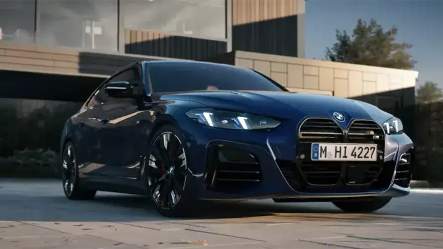 Blauer BMW vor modernem Gebäude, seitliche Vorderansicht, bei Tageslicht geparkt.