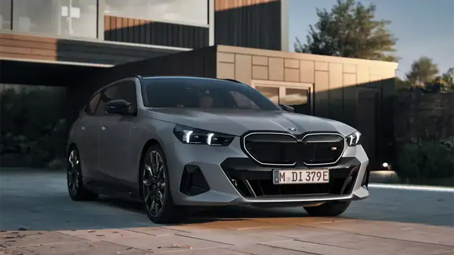 Schwarzer BMW Kombi steht auf weißem Hintergrund, Seitenansicht links.